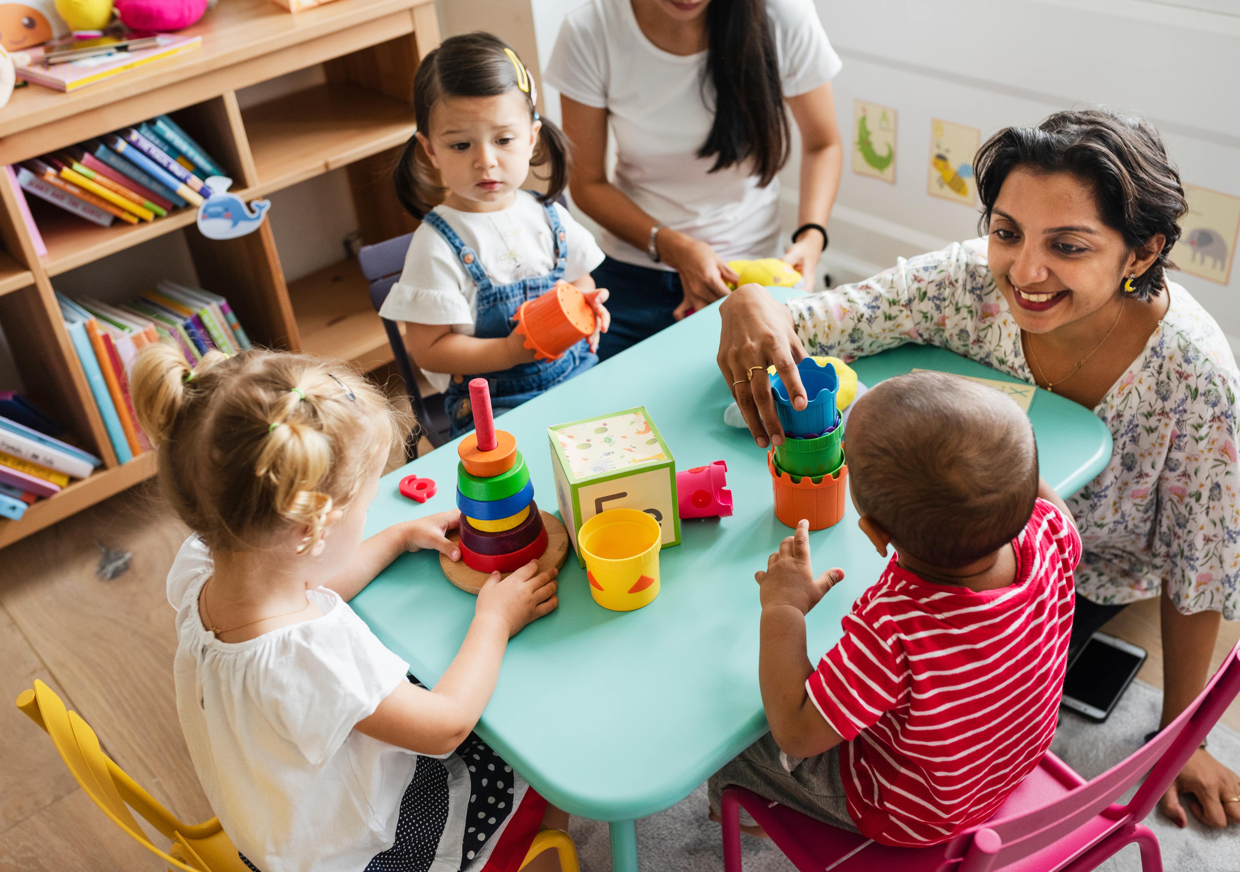 Teachers and young children at a classroom table